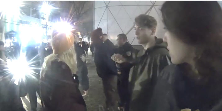 Shia LaBeouf, handcuffed, is taken away by policemen, caught on camera at hewillnotdivide.us
