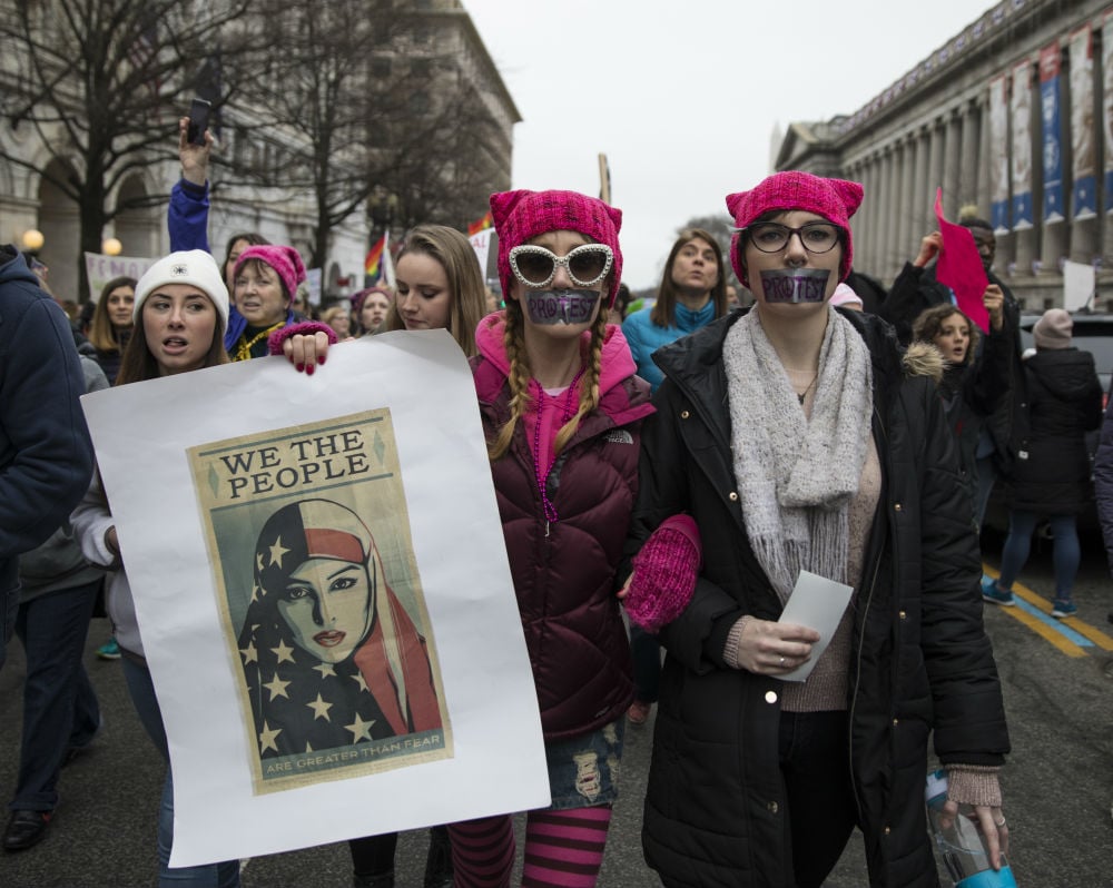 Marchers attending the Women's March on Washington hold up women's rights signs critical of President Donald Trump on January 21, 2017 in Washington, DC. President Trump was sworn in as the country's 45th President the day before. Photo by Robert Nickelsberg/Getty Images.