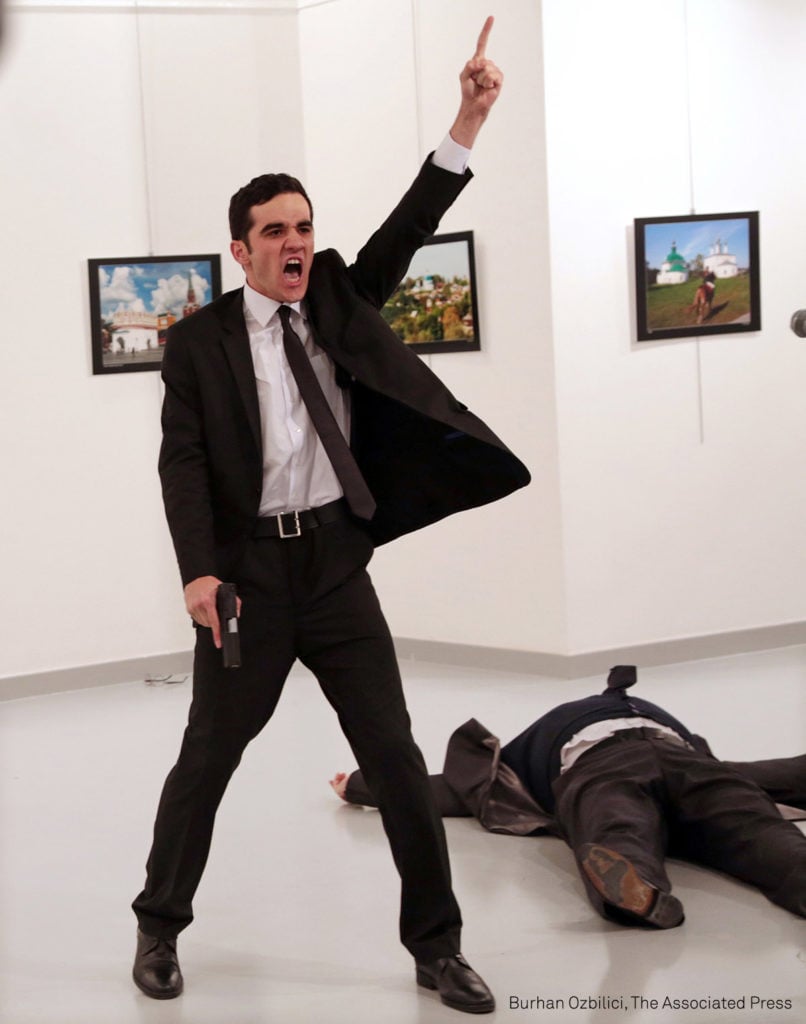 Mevlut Mert Altintas shouts after shooting Andrei Karlov, right, the Russian ambassador to Turkey, at an art gallery in Ankara, Turkey, Monday, Dec. 19, 2016. Photo Burhan Ozbilici, courtesy AP.