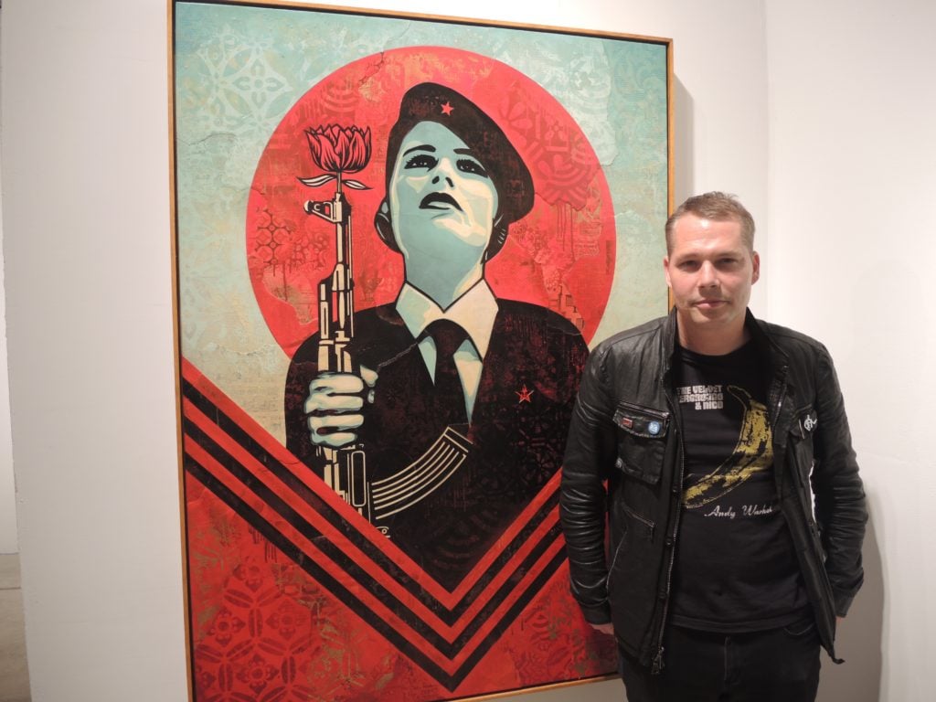 Shepard Fairey with his piece <em>Peace Guard 2</em> at Jacob Lewis Gallery at Art Wynwood. Courtesy of Sarah Cascone. 