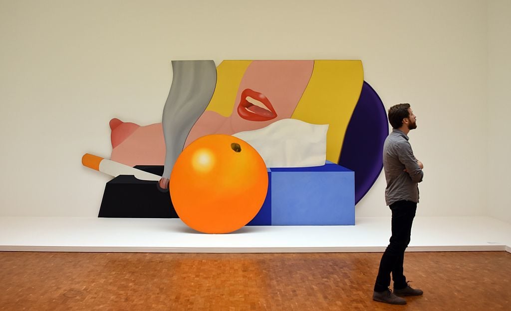 A visitor stands in front of the painting "Great American nude" from American artist Tom Wesselmann in 2014. Courtesy of PATRIK STOLLARZ/AFP/Getty Images.