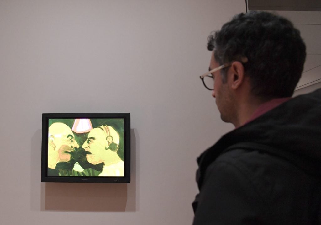 A man looks at artwork by Iranian artist Tala Madani "The Chit Chat, 2007" at The Museum of Modern Art on February 3, 2017 in New York City. Photo credit should read ANGELA WEISS/AFP/Getty Images.