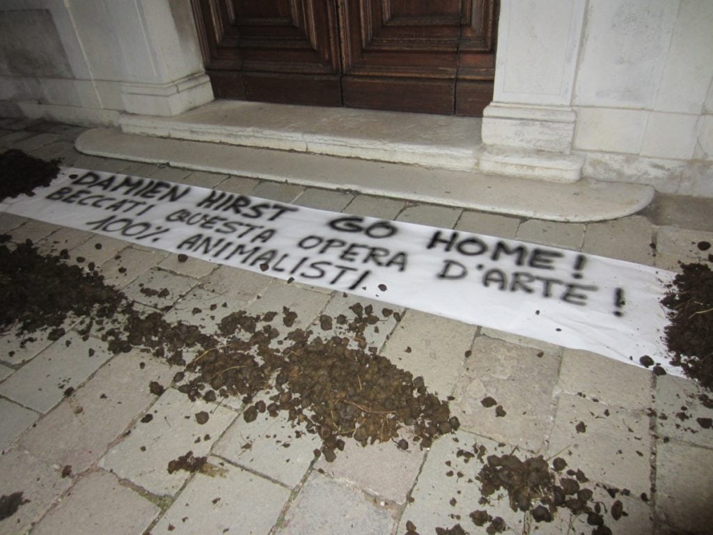Dung and banner outside the Palazzo Grassi in Venice, in protest of Damien Hirst's upcoming exhition. Courtesy 100% Animalisti.
