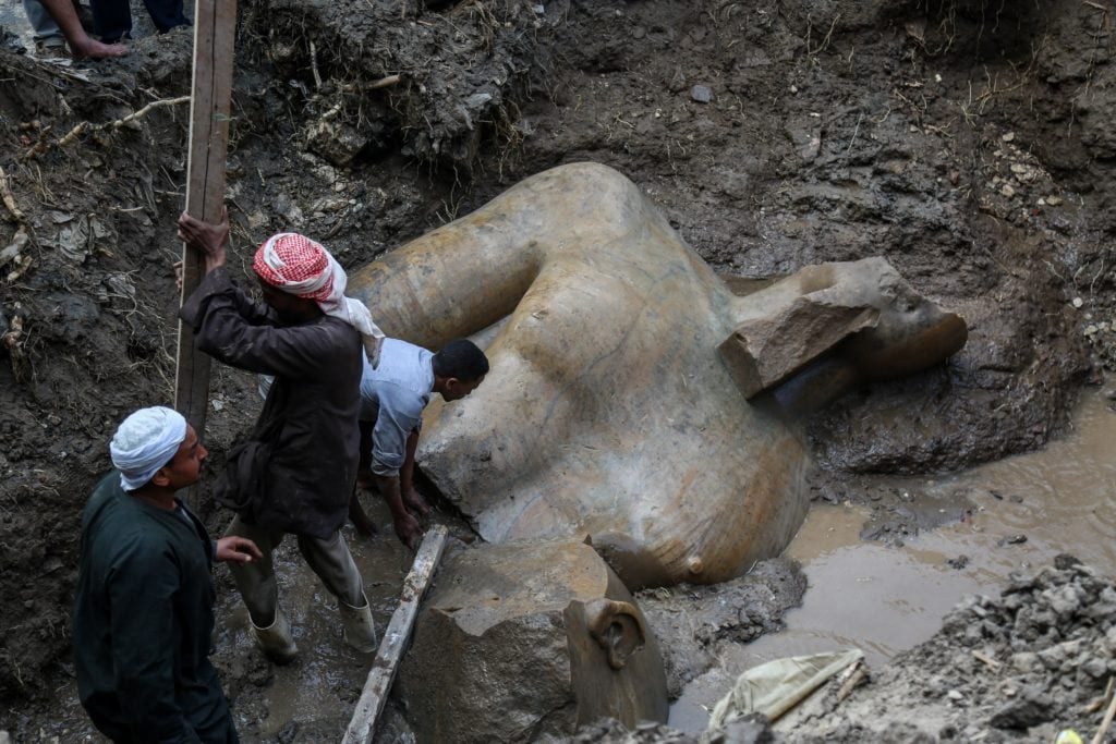 A quartzite colossus, possibly of Ramses II, and limestone bust of Seti II are seen after they were discovered at the ancient Heliopolis archaeological site in Matareya area in Cairo, Egypt on March 9, 2017. The statues were found in parts in the vicinity of the King Ramses II temple in the temple precinct of ancient Heliopolis, also known as Oun, by a German-Egyptian archaeological mission. Courtesy of Ibrahim Ramadan/Anadolu Agency/Getty Images.