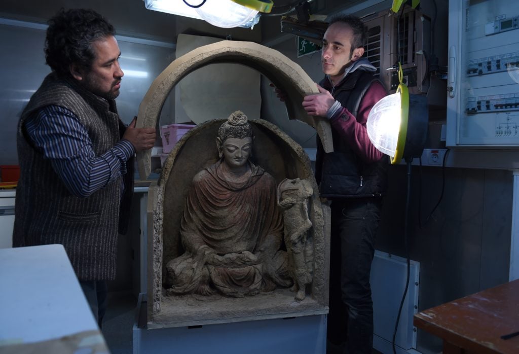 Italian restoration experts unveil a statue of Buddha in Kabul. Courtesy WAKIL KOHSAR/AFP/Getty Images.