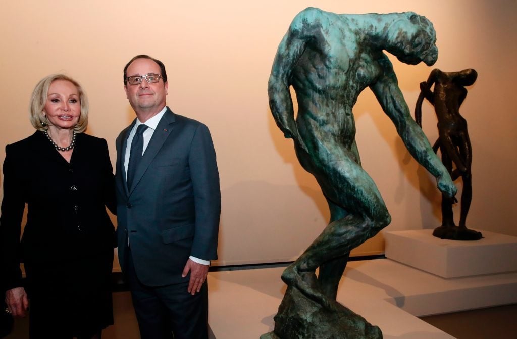 French President François Hollande and US philanthropist Iris Cantor, head of the Cantor Foundation, pose by sculptures of late French sculptor Auguste Rodin, during the opening of an exhibition at the Grand Palais in Paris on March 20, 2017 marking the centenary of the death of the French artist (1840-1917). Photo credit CHRISTIAN HARTMANN/AFP/Getty Images.