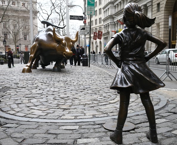 The "Fearless Girl" statue, a four-foot statue of a young girl, defiantly looks up the iconic Wall Street "Charging Bull" sculpture in New York City, United States on March 29, 2017. "Fearless Girl" statue was installed in front of the bronze "Charging Bull" for International Women's Day earlier this month to draw attention to the gender pay gap and lack of gender diversity on corporate boards in the financial sector. The statue will remain at her post until February 2018. (Photo by Volkan Furuncu/Anadolu Agency/Getty Images)