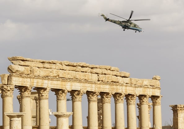 A Russian Mil Mi-24 'Hind' attack helicopter flying above the damaged site of the ancient city of Palmyra in central Syria. Syrian troops backed by Russian jets completed the recapture of the historic city of Palmyra from Islamic State (IS) group fighters on March 2, 2017, the Kremlin and the army said. Photo: Louai Beshara/AFP/Getty Images.