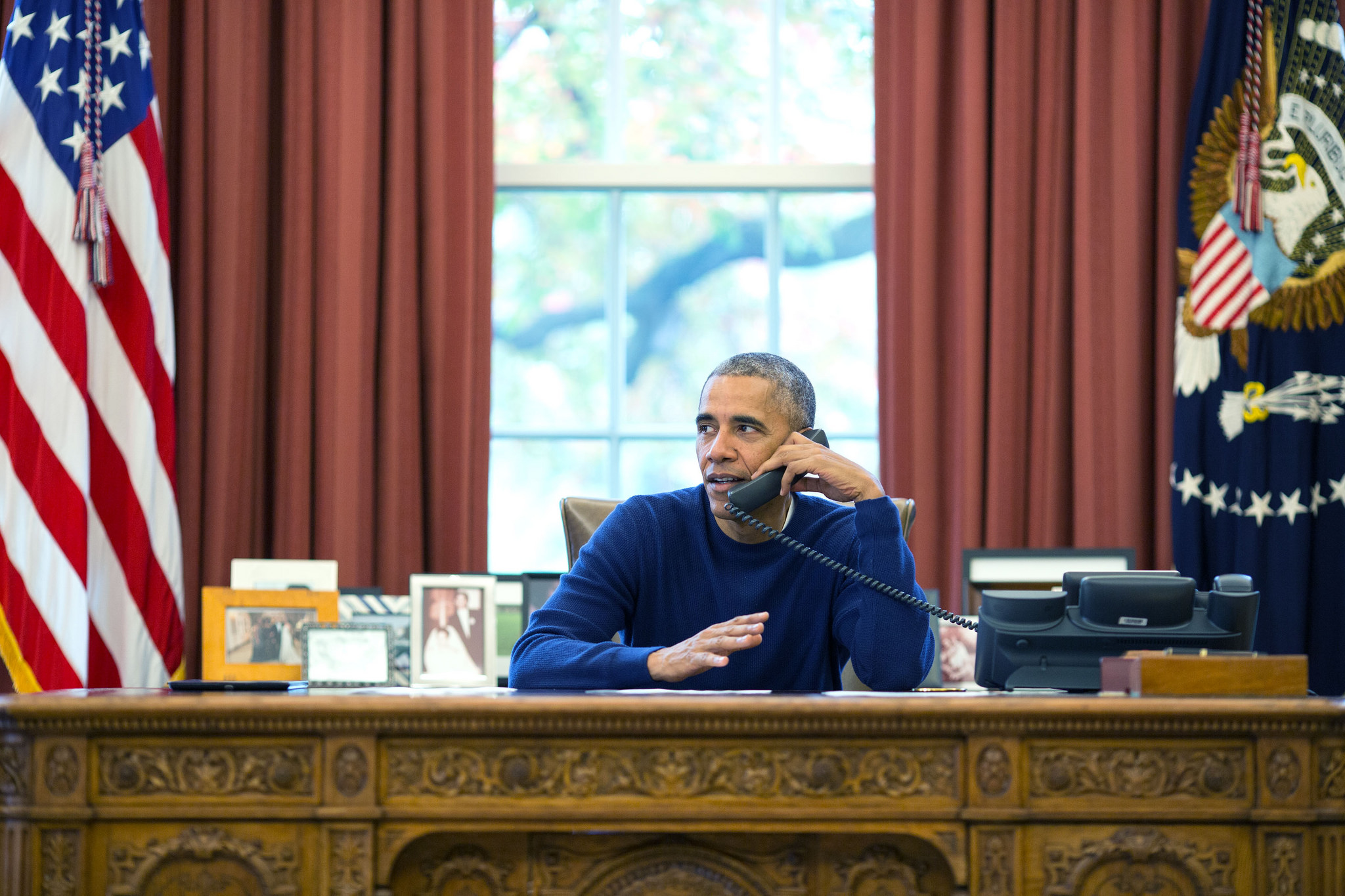 Pete Souza, President Barack Obama makes Thanksgiving Day phone calls from the Oval Office to US troops stationed around the world, Nov. 24, 2016. Courtesy of the White House, via Flickr.