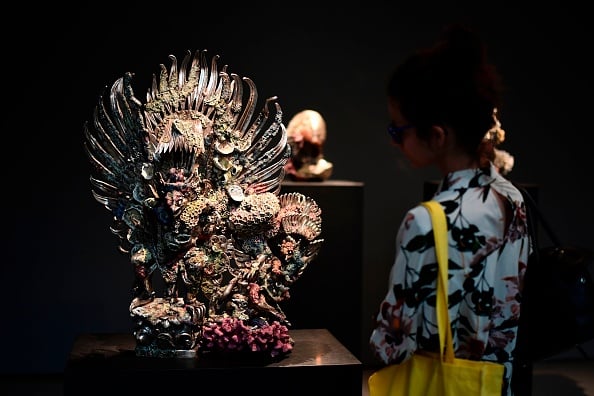  A woman looks at a silver sculture titled <em>Two Garudas</em> by British artist Damien Hirst during the press presentation of his exhibition “Treasures from the Wreck of the Unbelievable” at the Pinault Collection in Punta della Dogana and Palazzo Grassi in Venice on April 6, 2017. Photo credit should read Miguel Medina/AFP/Getty Images.