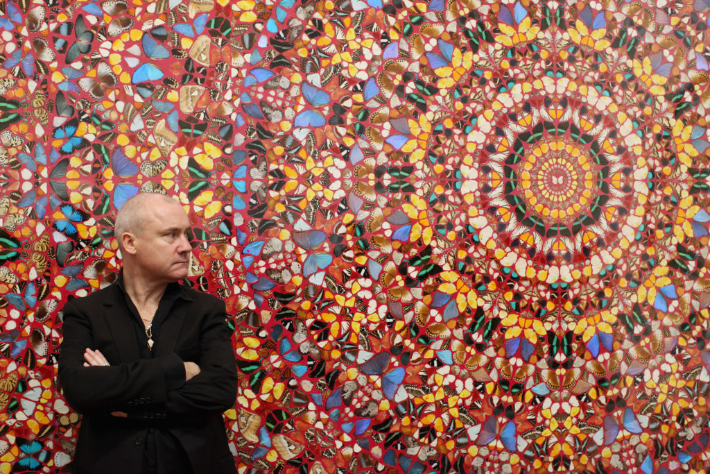 Damien Hirst poses in front of his artwork I am Become Death, Shatterer of Worlds at London's Tate Modern in 2012. Photo Oli Scarff/Getty Images.