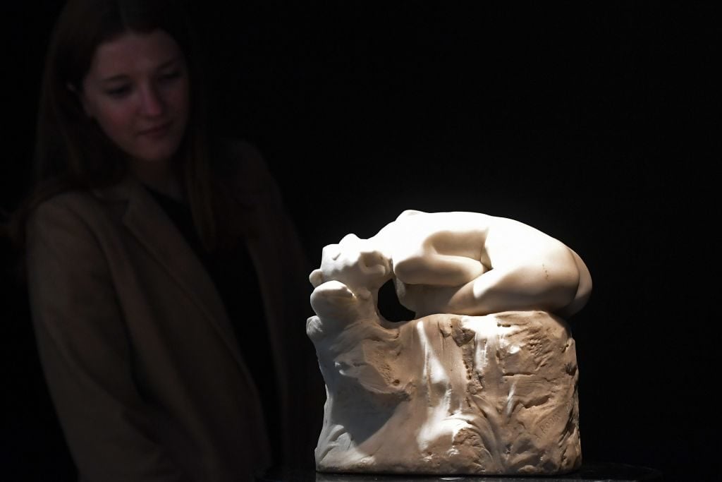 A woman looks at Andromede a marble sculpture by late French sculptor Auguste Rodin on March 21, 2017 at Artcurial Paris. Photo courtesy GABRIEL BOUYS/AFP/Getty Images.