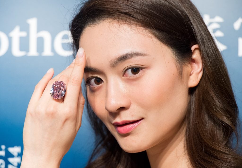 A model shows the 59.60 carat Pink Star diamond ring at Sotheby's Hong Kong. Courtesy of Jayne Russell/Anadolu Agency/Getty Images.