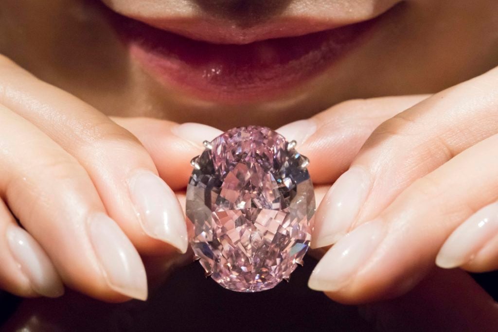 A model shows the 59.60 carat Pink Star diamond ring at Sotheby's Hong Kong. Courtesy of studioEAST/Getty Images.