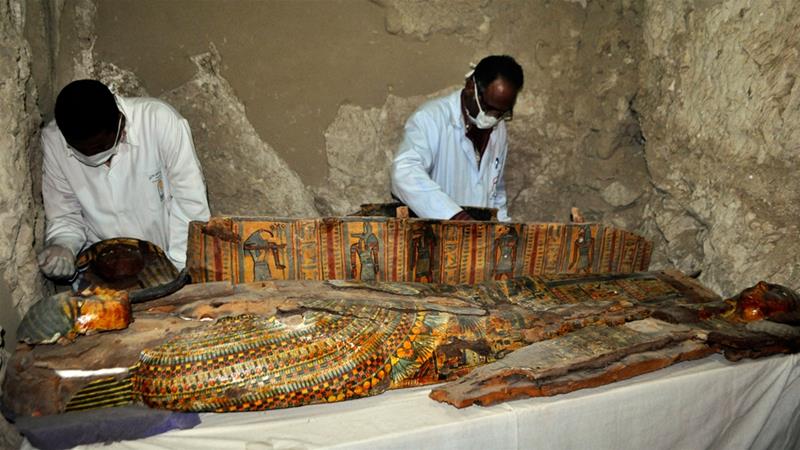 Members of an Egyptian archaeological team work on a wooden coffin discovered in a 3,500-year-old tomb in the Draa Abul Nagaa necropolis, near the southern Egyptian city of Luxor, on April 18, 2017. Egyptian archaeologists have discovered six mummies, colorful wooden coffins and more than 1,000 funerary statues in the 3,500-year-old tomb, the antiquities ministry said. Courtesy of Stringer/AFP/Getty Images.