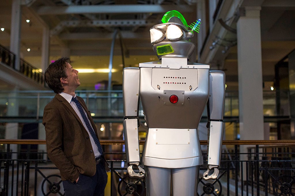 Curator Ben Russell poses with a robot called Cygan, built in 1957, at the Science Museum in London. Courtesy of Jack Taylor/Getty Images.