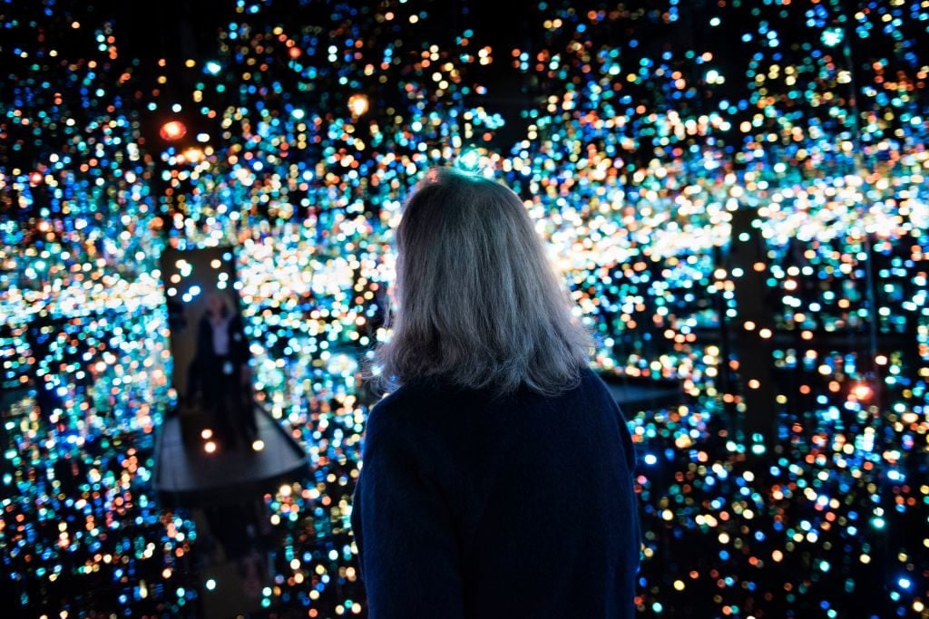 A visitor enters The Souls of Millions of Light Years Away during a preview of Yayoi Kusama's Infinity Mirrors exhibit. Photo by Brendan Smialowski/AFP/Getty Images.