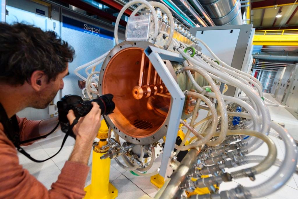 A photographer takes a picture of a prototype of the tube of the new linear accelerator Linac 4, at the European Organization for Nuclear Research (CERN) on May 9, 2017 in Meyrin near Geneva. Courtesy of Fabrice Coffrini/AFP/Getty Images.
