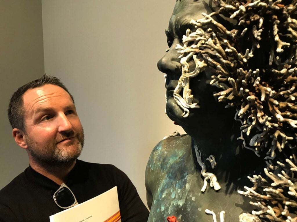 Jason deCaires Taylor with Damien Hirst's The Collector, a self-portrait of Hirst. Image courtesy Jason deCaires Taylor.