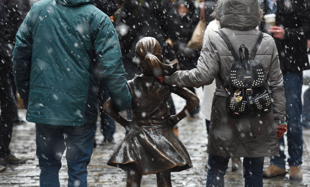 Tourist venture out to take photos of Fearless Girl on Wall Street in March. Photo by Timothy A. Clary/AFP/Getty Images.