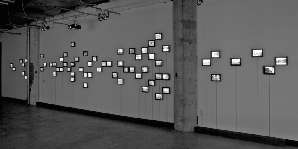 Hasan Elahi (American, b. 1972). Hiding in Plain Sight, 2011, 85-channel media installation, as installed at Intersection for the Arts, San Francisco, California. Courtesy of the artist.