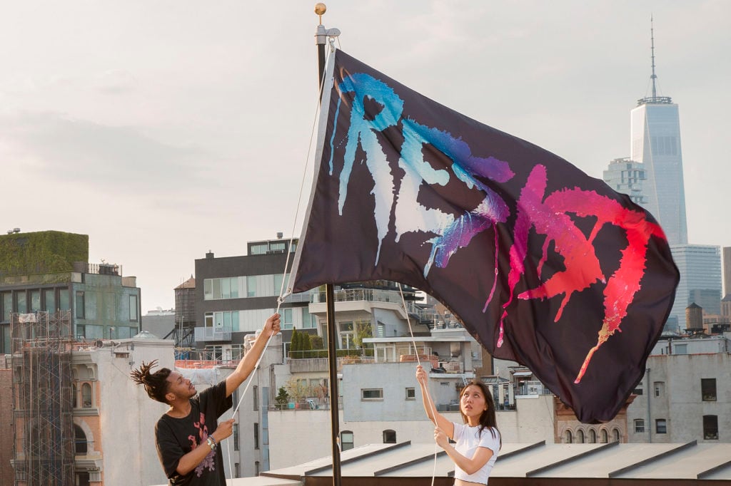Marilyn Minter's RESIST flag (2017) being raised on the Creative Time rooftop. Courtesy of Creative Time/photographer Guillaume Ziccarelli.