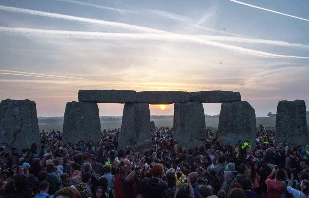 Revellers watch the sunrise as they celebrate the pagan festival of Summer Solstice at Stonehenge in Wiltshire, southern England on June 21, 2017. Photo: CHRIS J RATCLIFFE/AFP/Getty Images.