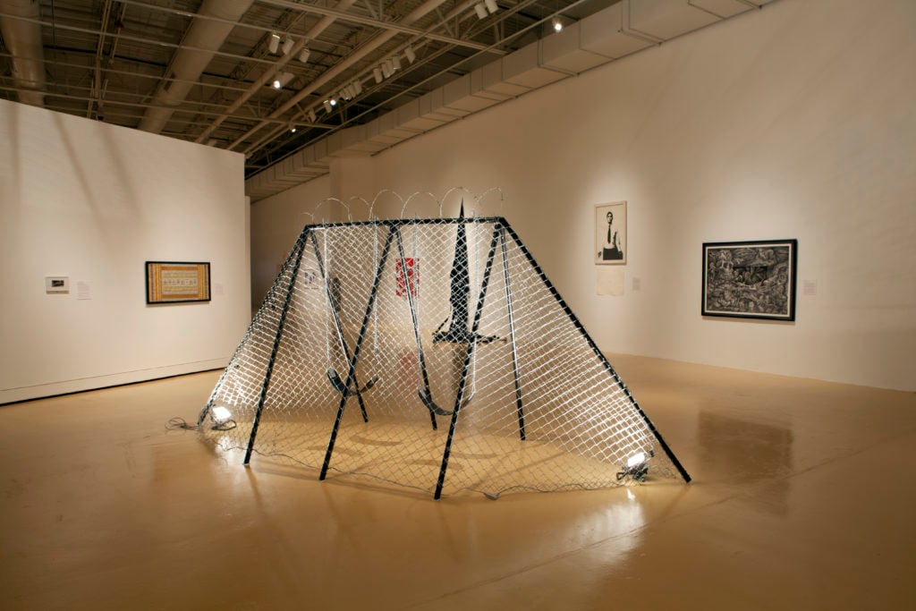 Work from a previous edition of the Transborder Biennial on view at the El Paso Museum of Art, including Angel Cabrales's <em>Juegos Fronteras: Swingset Penitentiary</em> at center. Courtesy of the El Paso Museum of Art.