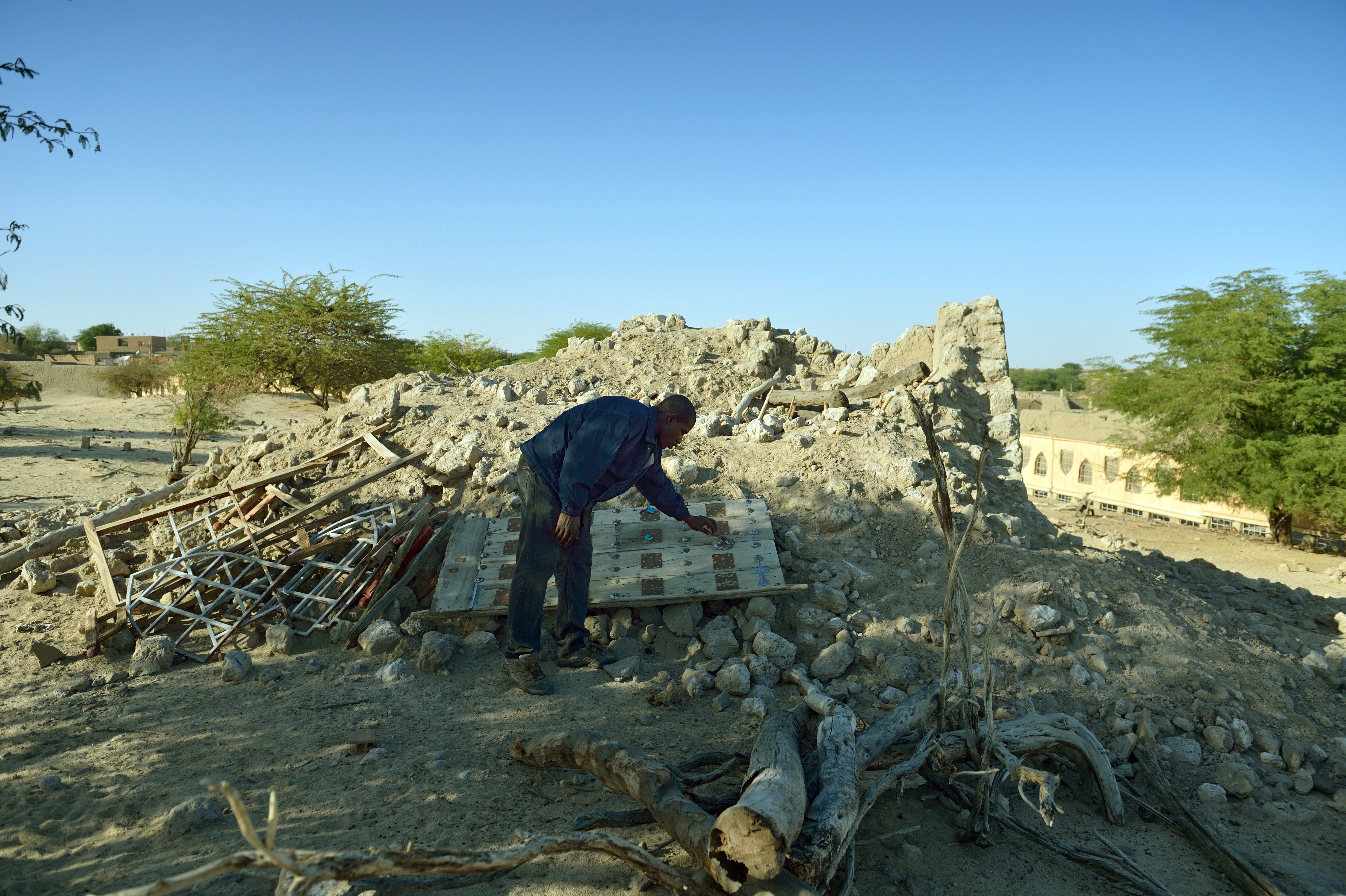 A man checks on January 29, 2013 the ruins of the mausoleum of Alfa Moya, a Muslim saint, which was destroyed by Islamists in July, in a cemetery of Timbuktu. French-led troops freed the northern desert city on January 28 from Islamist control. Hundreds of Malians looted Arab-owned shops on January 29 in Timbuktu as global donors pledged over 455 million US dollars (340 million euro) at a donor conference in the Ethiopian capital Addis Ababa for military operations in Mali and humanitarian aid to rout the radicals from the north. Photo: Eric Feferberg/Getty Images.