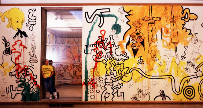 Keith Haring at Cranbrook Art Museum (1987). Photograph by Tseng Kwong Chi, © Muna Tseng Dance Projects, New York. Artwork © Keith Haring Foundation, New York.