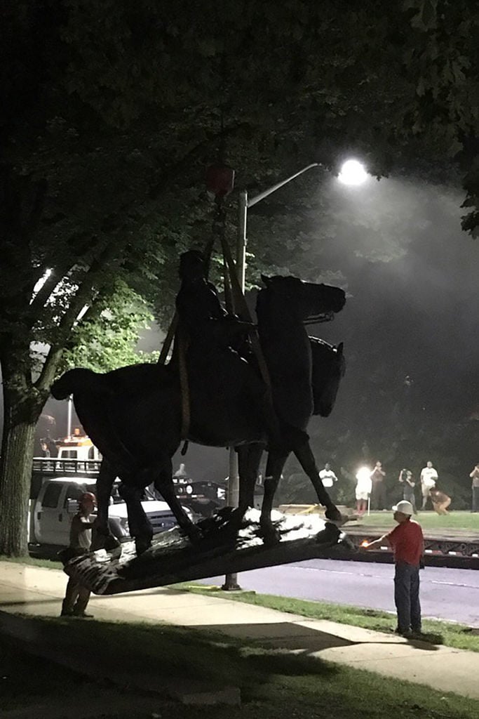 Workers load statues of Confederate generals Robert E. Lee and Thomas "Stonewall" Jackson on a flatbed truck in the early hours of August 16, 2017 in Baltimore, Maryland. Photo credit should read Alec MacGillis/AFP/Getty Images.