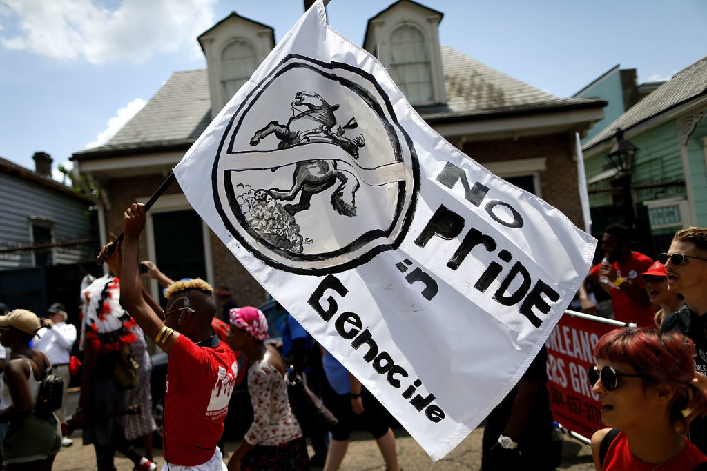 A protester carries a flag in support of removing a monument of Andrew Jackson during a demonstration in solidarity with Charlottesville on August 19, 2017 in New Orleans, Louisiana. Photo by Jonathan Bachman/Getty Images.