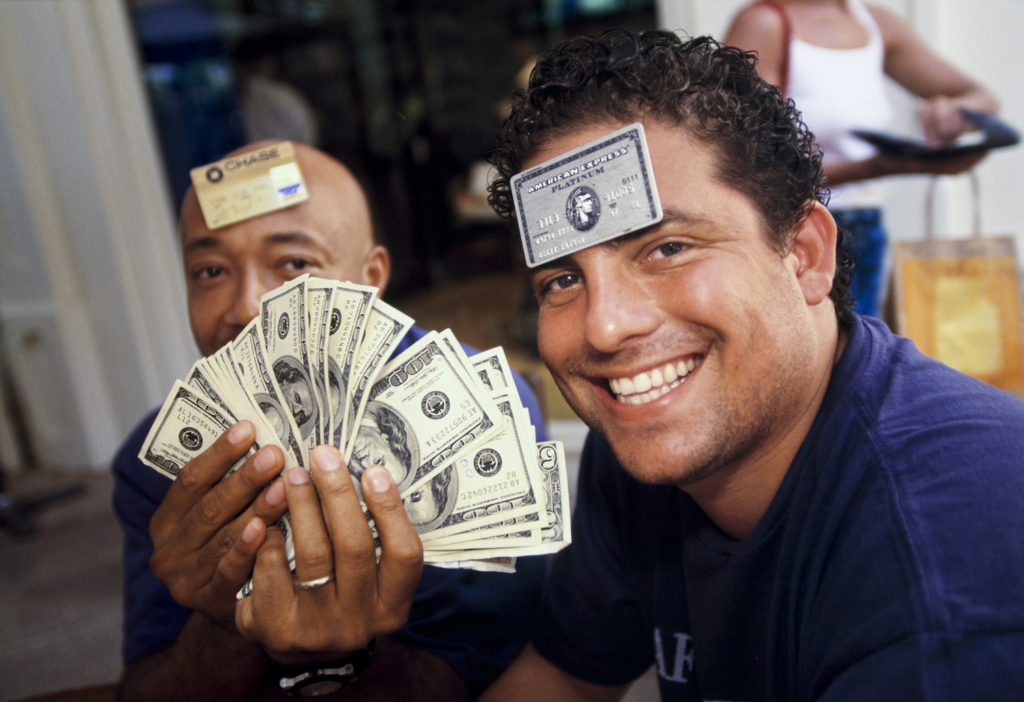 Film director and producer Brett Ratner (right), 29, and Russell Simmons, 41, a businessman and cofounder of hip-hop label Def Jam, at L’Iguane restaurant, St. Barts, 1998. Few establishments on the island accepted credit cards, and visitors often carried large amounts of cash. © Lauren Greenfield.