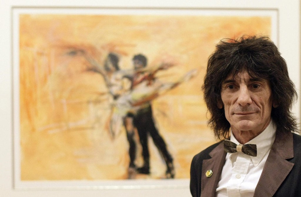 Rolling Stones British guitarist Ronnie Wood poses in front of his painting called <em>A Study of Carlos and Darcey Rehearsing</em> in 2008. Courtesy of Shaun Curry/AFP/Getty Images.