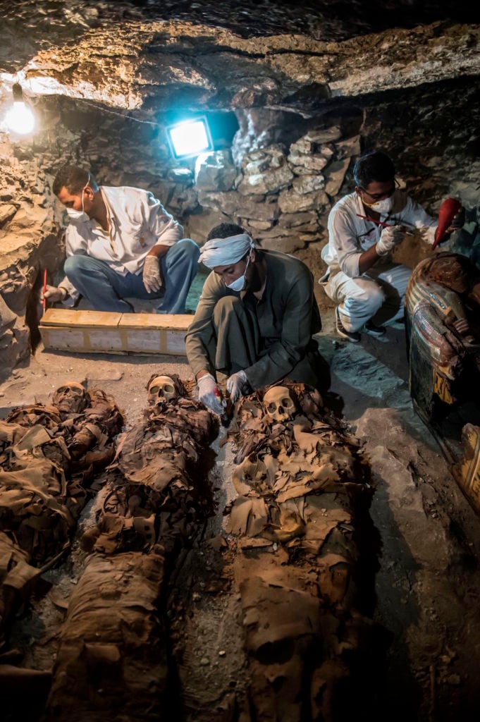 Egyptian archaeologists unearthing mummies at a newly-uncovered ancient tomb in Luxor. Courtesy of Khaled Desouki/AFP/Getty Images.