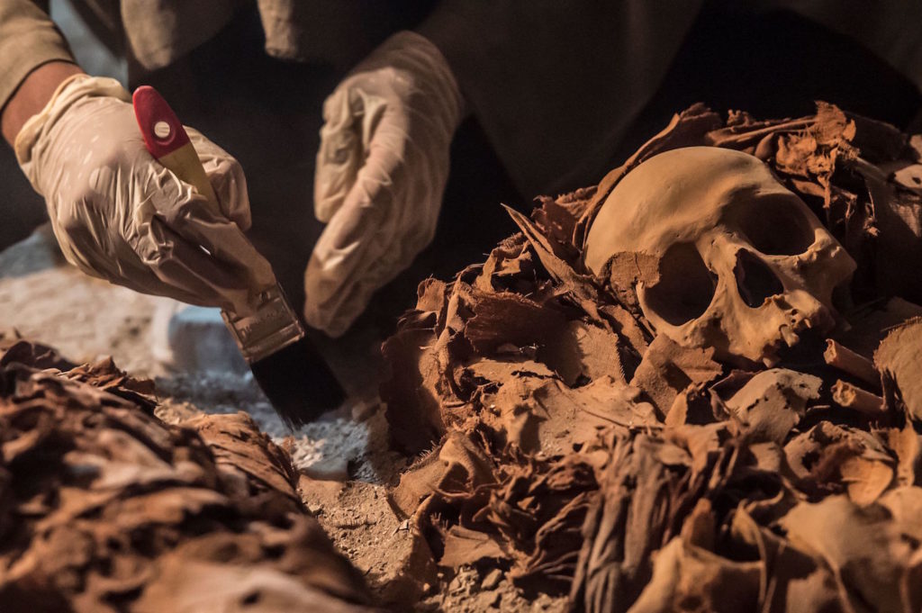 Egyptian archaeologists unearthing mummies at a newly-uncovered ancient tomb in Luxor. Courtesy of Khaled Desouki/AFP/Getty Images.
