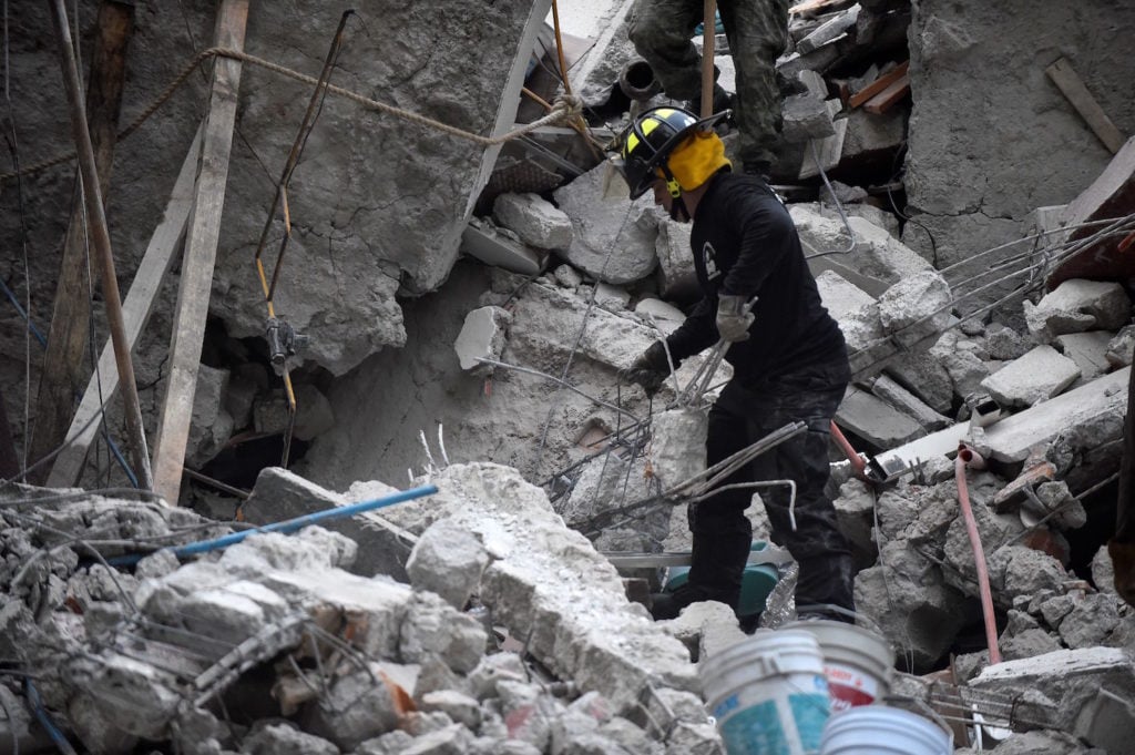 Volunteers remove rubble during the search for survivors in a flattened building in Mexico City on September 20, 2017 after a strong quake hit central Mexico on the eve killing at least 240 people. Courtesy of Pedro Pardo/AFP/Getty Images.