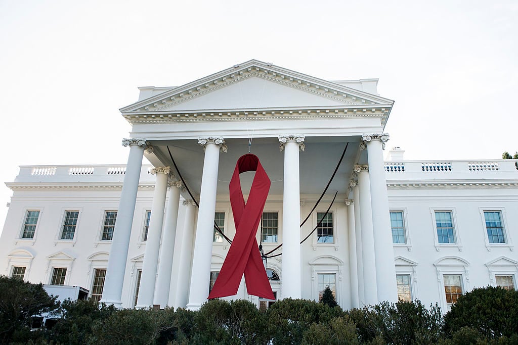 A red ribbon is seen on the North Portico of the White House in honor of World AIDS Day December 1, 2013 in Washington, DC. Photo credit should read Brendan Smialowski/AFP/Getty Images.