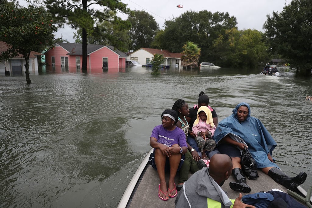 Evacuees sit on a boat after being rescued from flooding from Hurricane Harvey on August 30, 2017 in Port Arthur, Texas. Photo by Joe Raedle/Getty Images.