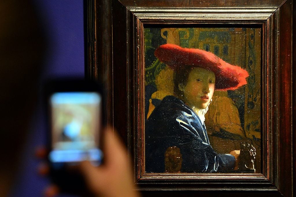 A visitor takes a picture of Girl with the Red Hat by Dutch artist Johannes Vermeer on September 26, 2012 during the media preview of the exhibition of 