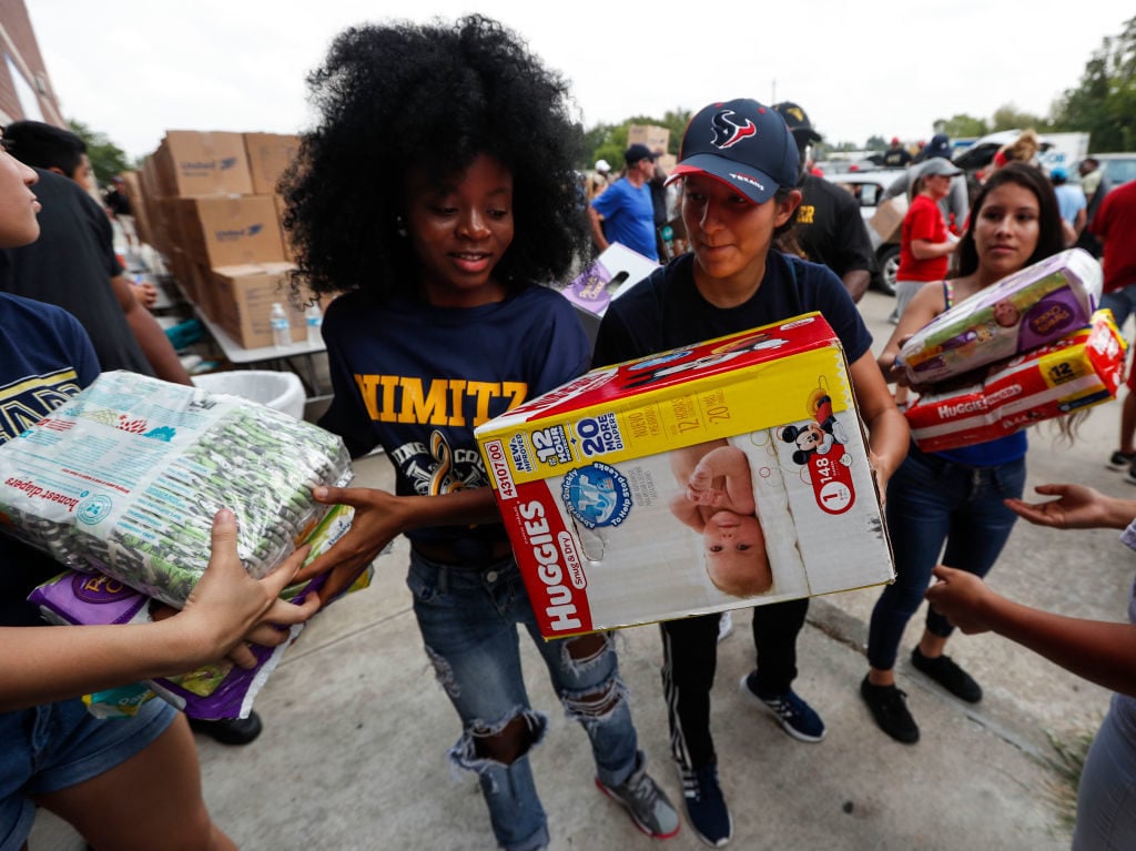 Student volunteer Nahimana Pascaziya (L) passes along diapers while helping to distribute relief supplies to people impacted by Hurricane Harvey on September 3, 2017 in Houston, Texas. Photo by Brett Coomer /Getty Images.