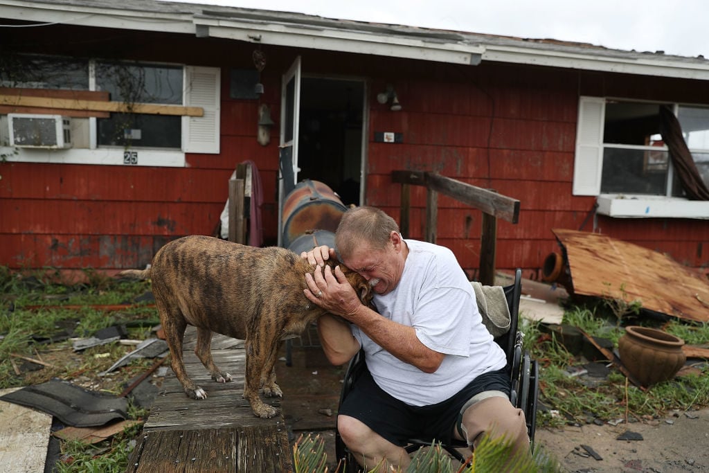 Steve Culver cries with his dog Otis as he talks about what he said was the, "most terrifying event in his life," when Hurricane Harvey blew in and destroyed most of his home while he and his wife took shelter there on August 26, 2017 in Rockport, Texas. Photo by Joe Raedle/Getty Images.