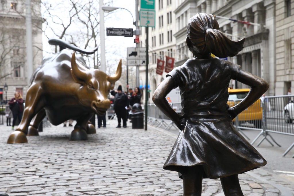 Kristen Visbal's Fearless Girl, a four-foot statue of a young girl, defiantly looks up at Arturo DiModica's iconic Wall Street Charging Bull sculpture in New York City. Fearless Girl was installed for International Women's Day in March to draw attention to the gender pay gap and lack of gender diversity on corporate boards in the financial sector. Courtesy of Volkan Furuncu/Anadolu Agency/Getty Images.
