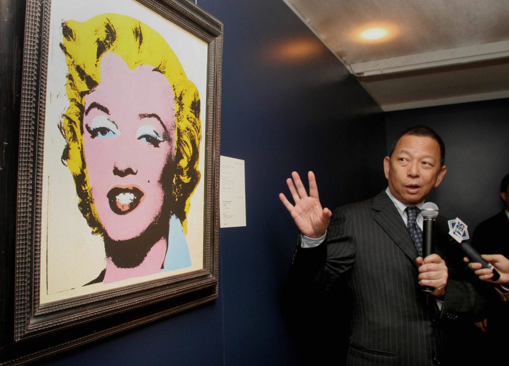 Ken Yeh, then deputy chairman of Christie's Asia, speaks about Andy Warhol's Lemon Marilyn when it was on display in Hong Kong. Photo Woody Wu/AFP/Getty Images.