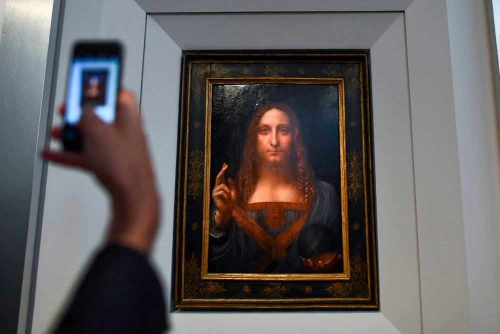 A journalist takes photos of Leonardo da Vinci's "Salvator Mundi" after it was unveiled at Christie's in New York on October 10, 2017. (Photo credit should read JEWEL SAMAD/AFP/Getty Images)