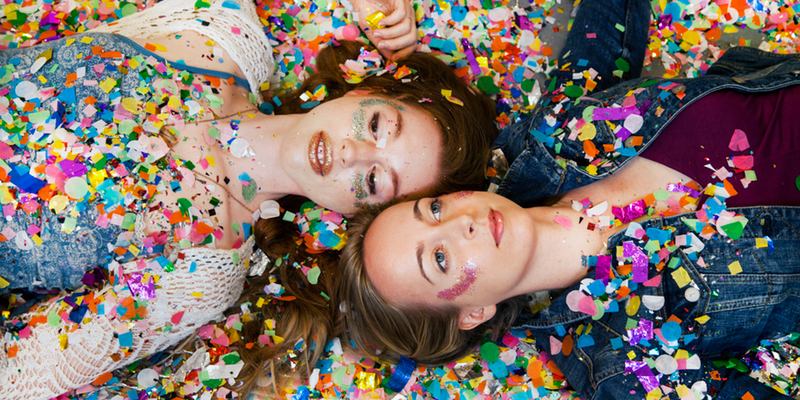 Two young women pose in confetti at the Artist and Fleas pop-up in June 2017. Photo courtesy of Jelena Aleksich and the Confetti Project.