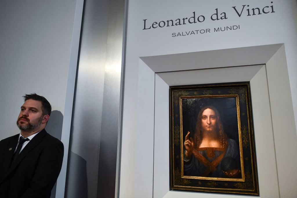 A security personnel stands next to Leonardo da Vinci's "Salvator Mundi" after it was unveiled at Christie's in New York on October 10, 2017. Photo by Jewel Samad/AFP/Getty Images.