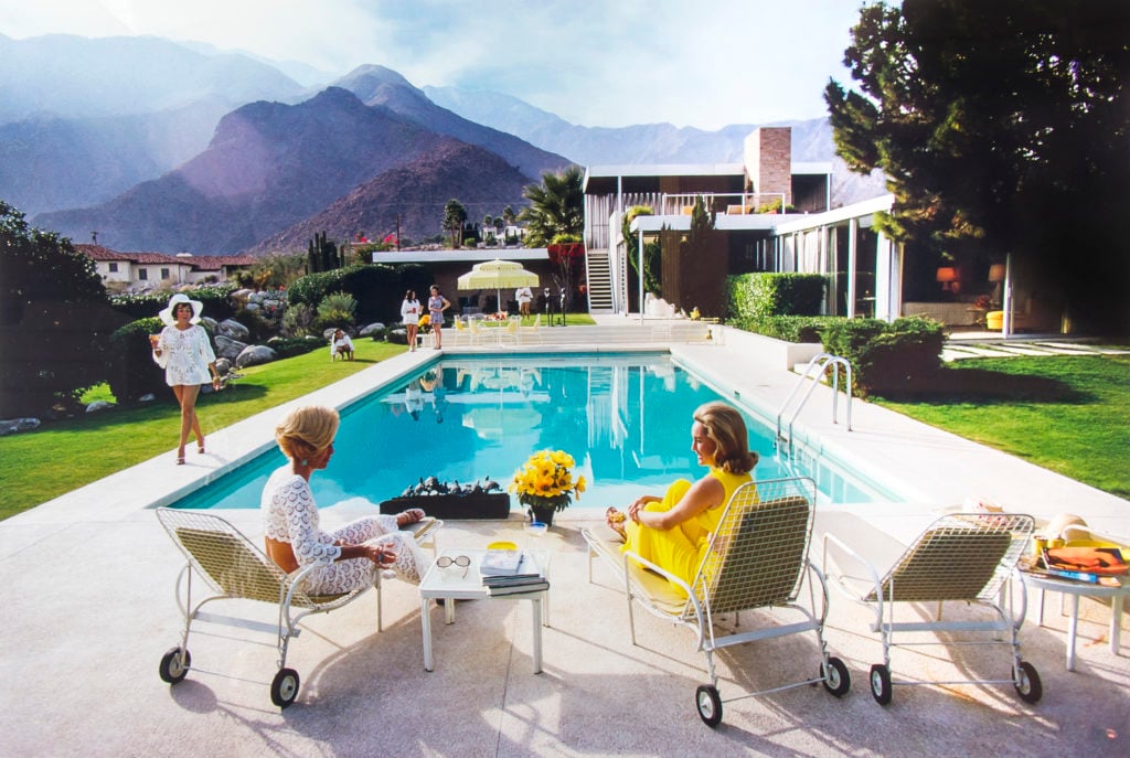 Slim Aarons's <i>Poolside Gossip</i> (1970). Courtesy of the Slim Aarons Estate. Reproduction, © Bloomsbury Auctions.