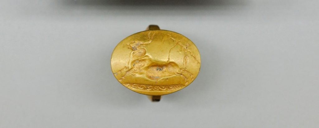 This gold ring with a Cretan bull-jumping scene was one of four solid-gold rings found in the Griffin Warrior Tomb. Photo courtesy of the University of Cincinnati.