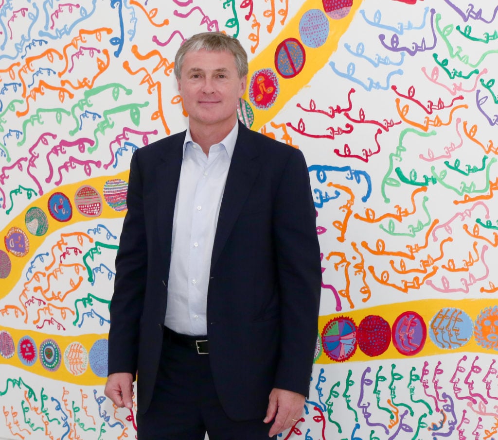 David Zwirner stands in front of an artwork by Yayoi Kusama. (Photo by Andrew Toth/Getty Images)